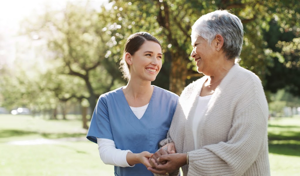 Senior woman going for a walk in the park with her nurse