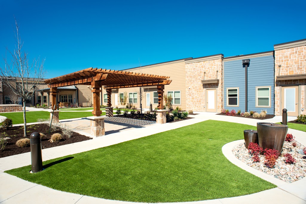 a backyard with artificial grass and landscaping
