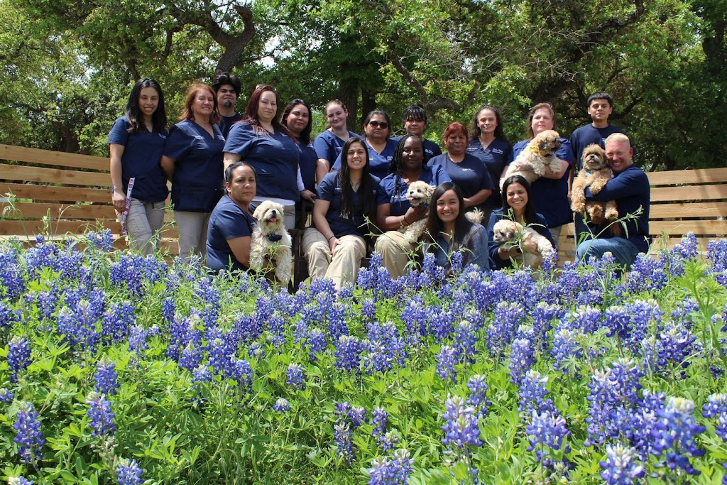 a group of people posing in a field of bluebonnets