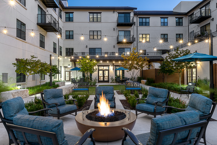 a patio with a fire pit and chairs