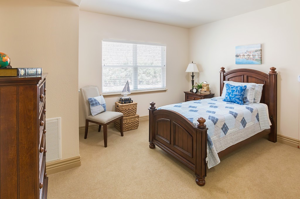a bedroom with a bed, dresser and chair