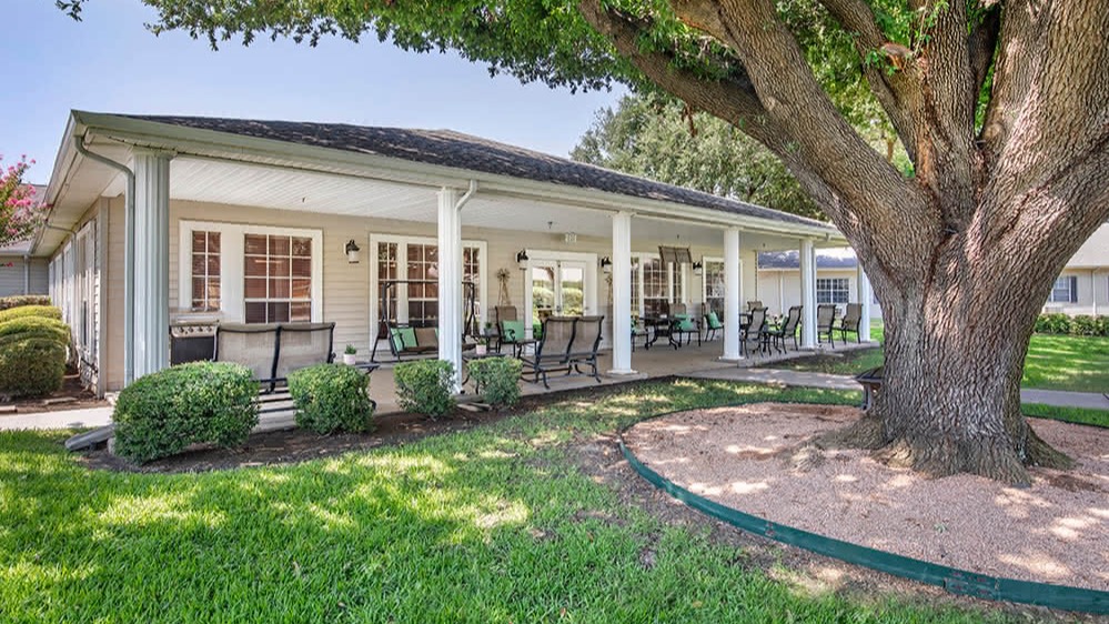 a white house with a tree in the yard