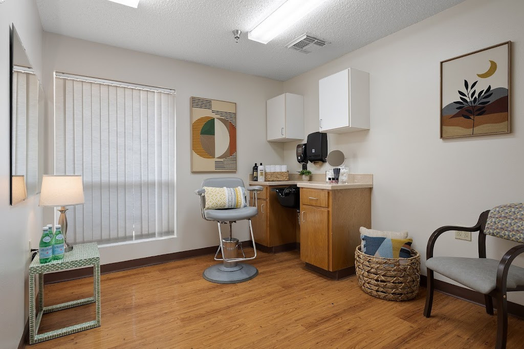 a room with a chair, desk and a window