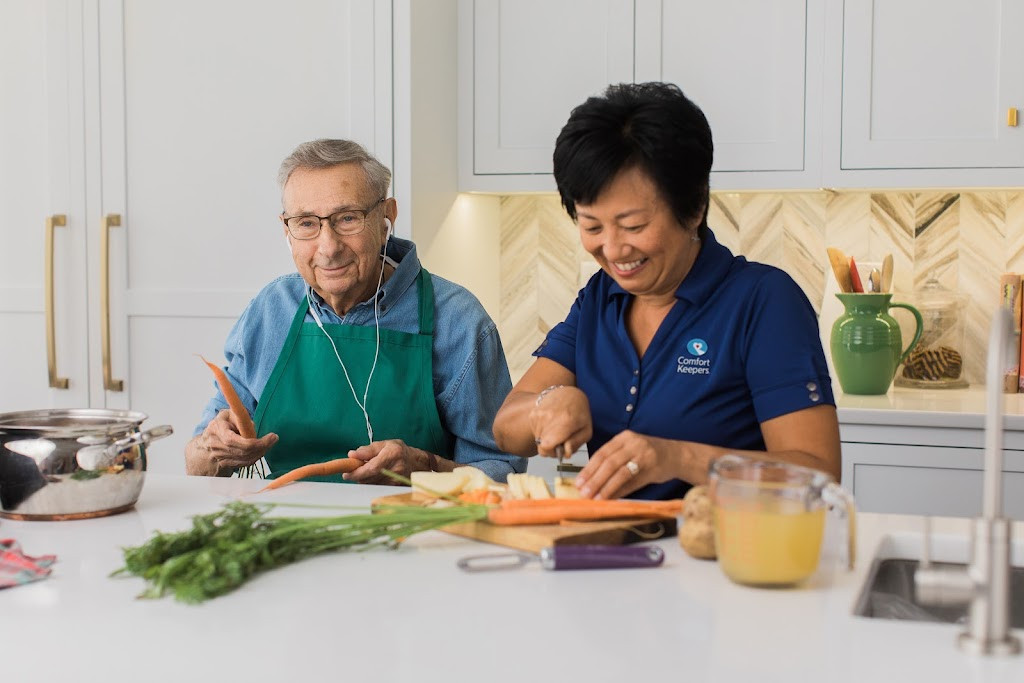 a woman and an older man preparing food in the kitchen