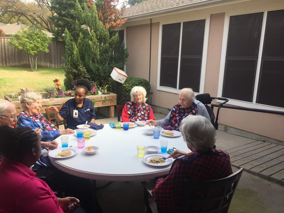 a group of people sitting around a table eating food