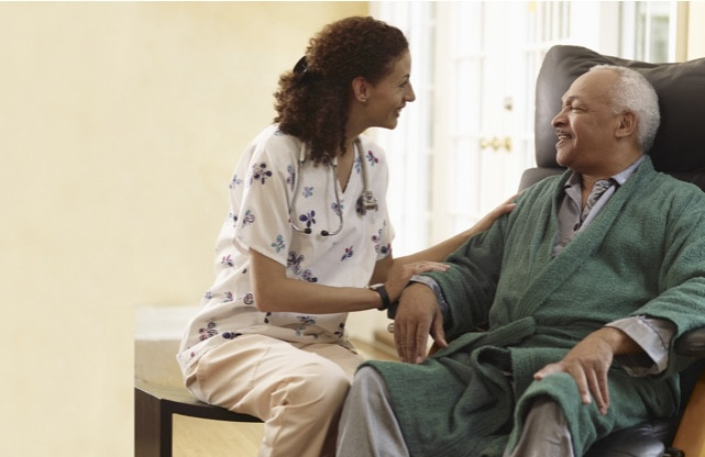 a woman sitting in a chair next to an older man