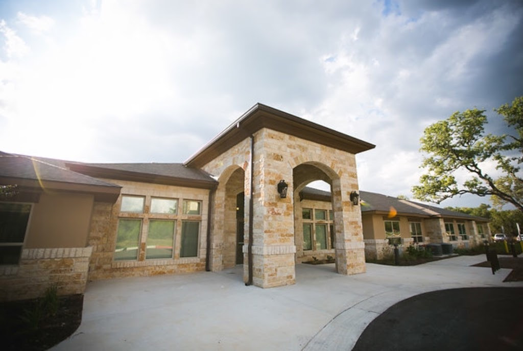 a home with a stone front entrance and a stone driveway