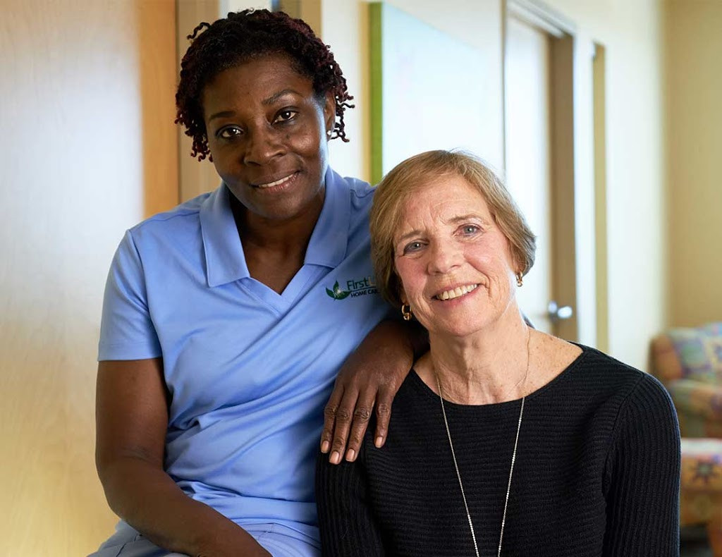 a woman sitting next to a woman who is smiling