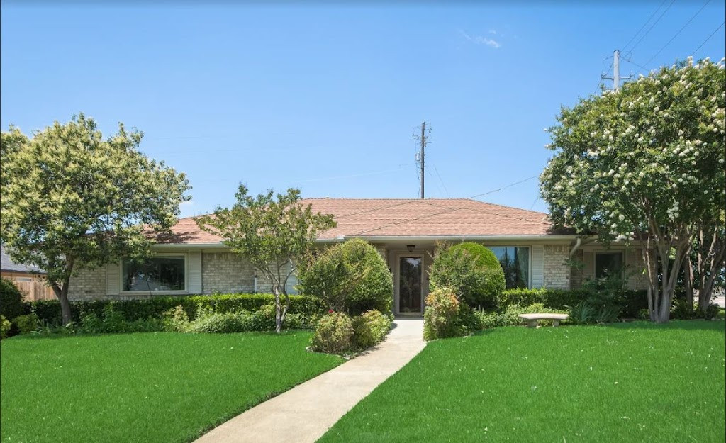 a house with a lawn and trees in the front yard