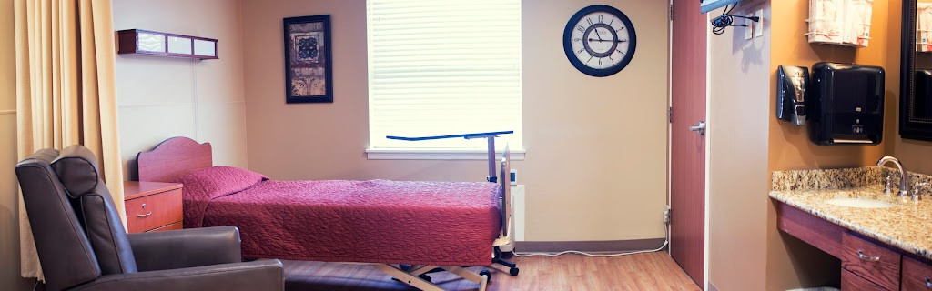 a small room with a bed, chair and television