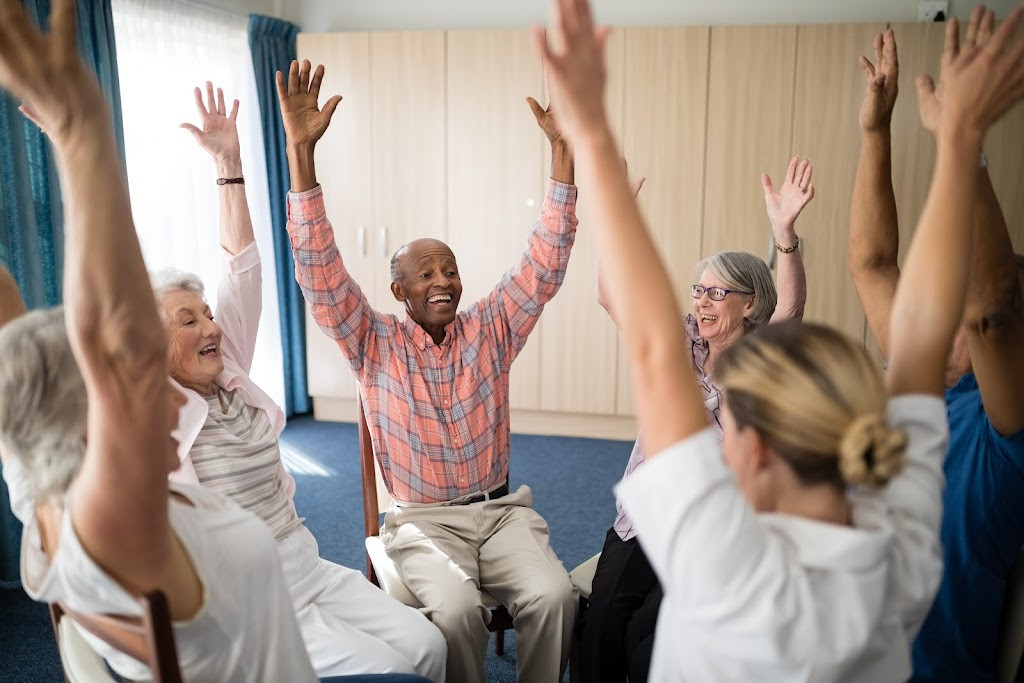 a group of people sitting in a room with their hands up