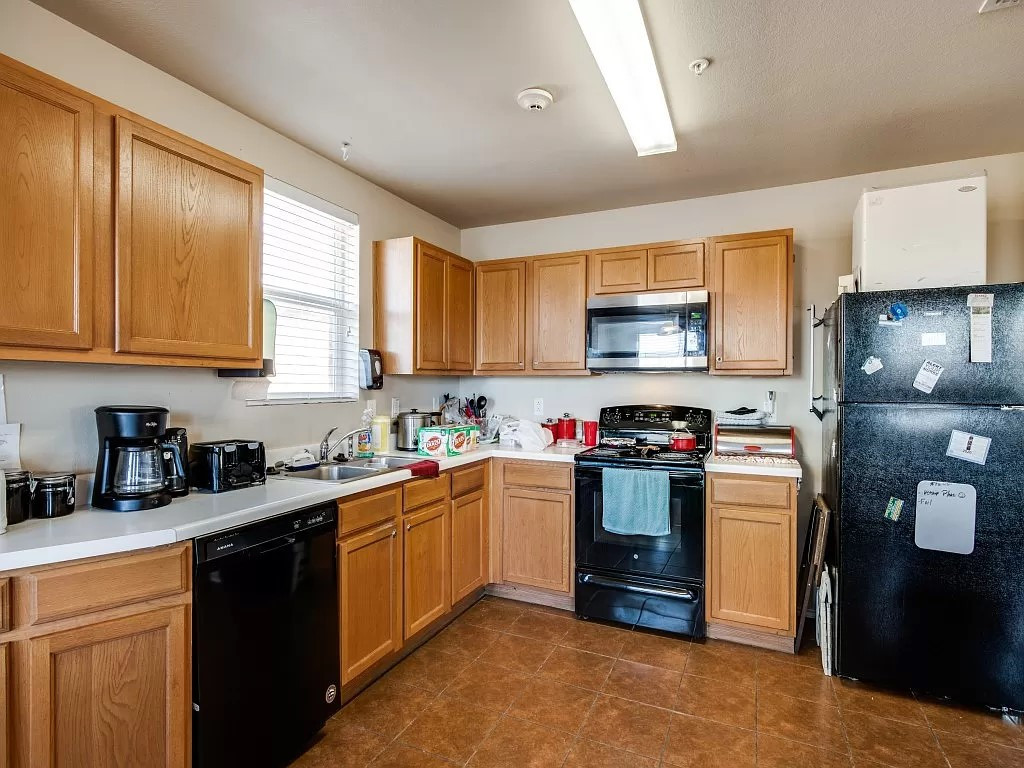 a kitchen with a black refrigerator and a black stove