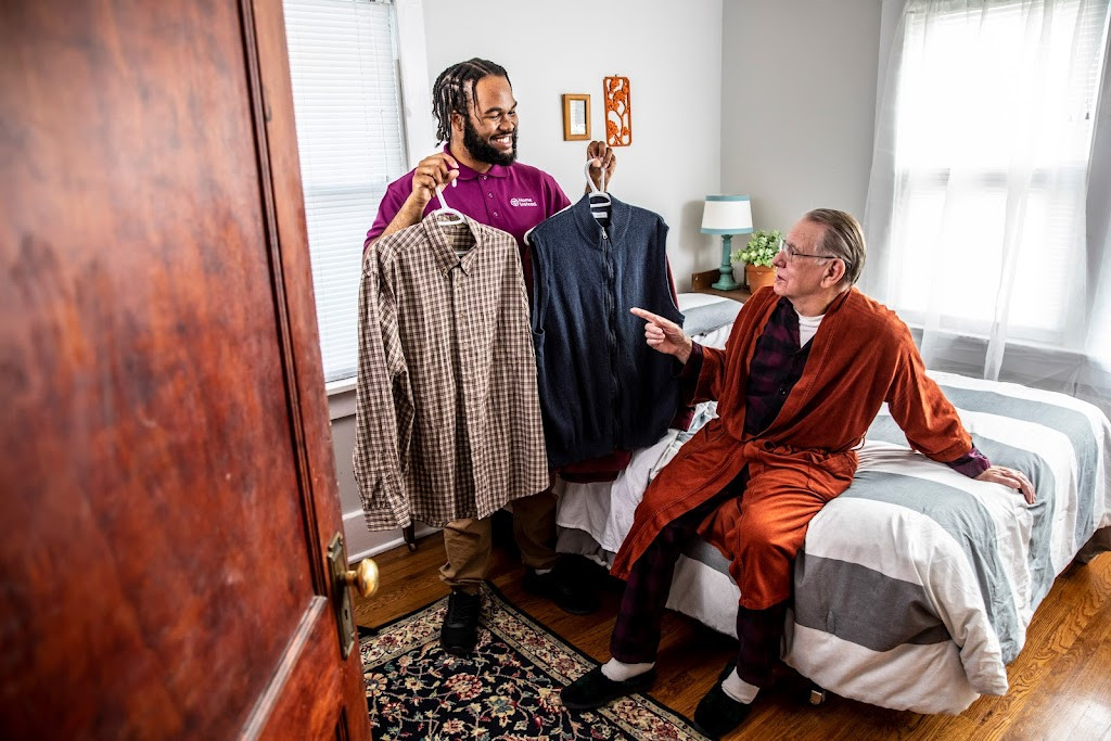 a man in a red robe is helping another man in a red robe