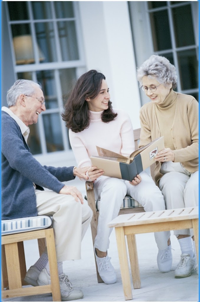 a woman sitting on a bench with an older man reading