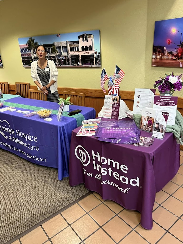 a woman standing behind a table with a purple table cloth