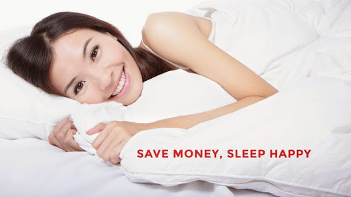 a woman laying on a bed with a white blanket