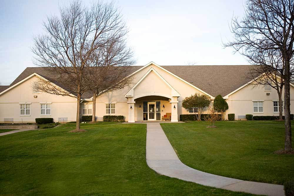 a house with a lawn and trees in front