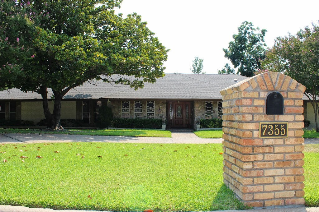 a brick house with a brick sign in front