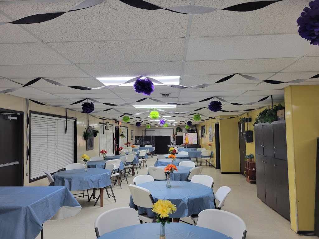 a room with tables and chairs and a ceiling with paper flowers